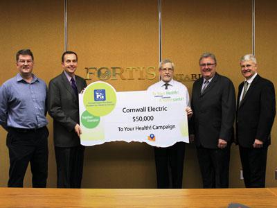 People holding large $50,000 cheque donated to the To Your Health! Campaign for an MRI and a digital urology table